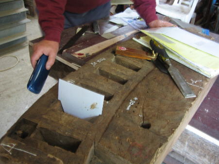 Metal template for teeth being checked for size in old section of a felloe