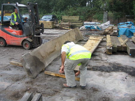 Selecting a plank of five year air dried oak at the timber-yard in Whitesmith, Sussex