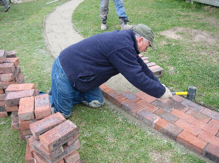 Roy laying the brick path