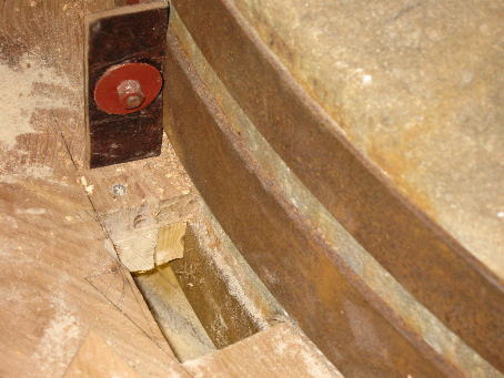 Leather scraper which rotates with the millstone and sweeps the flour down the hole into the spout