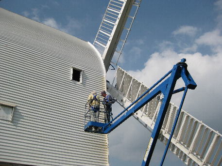 Using Roger's cherry picker to paint sides of mill. Skirt framing in position